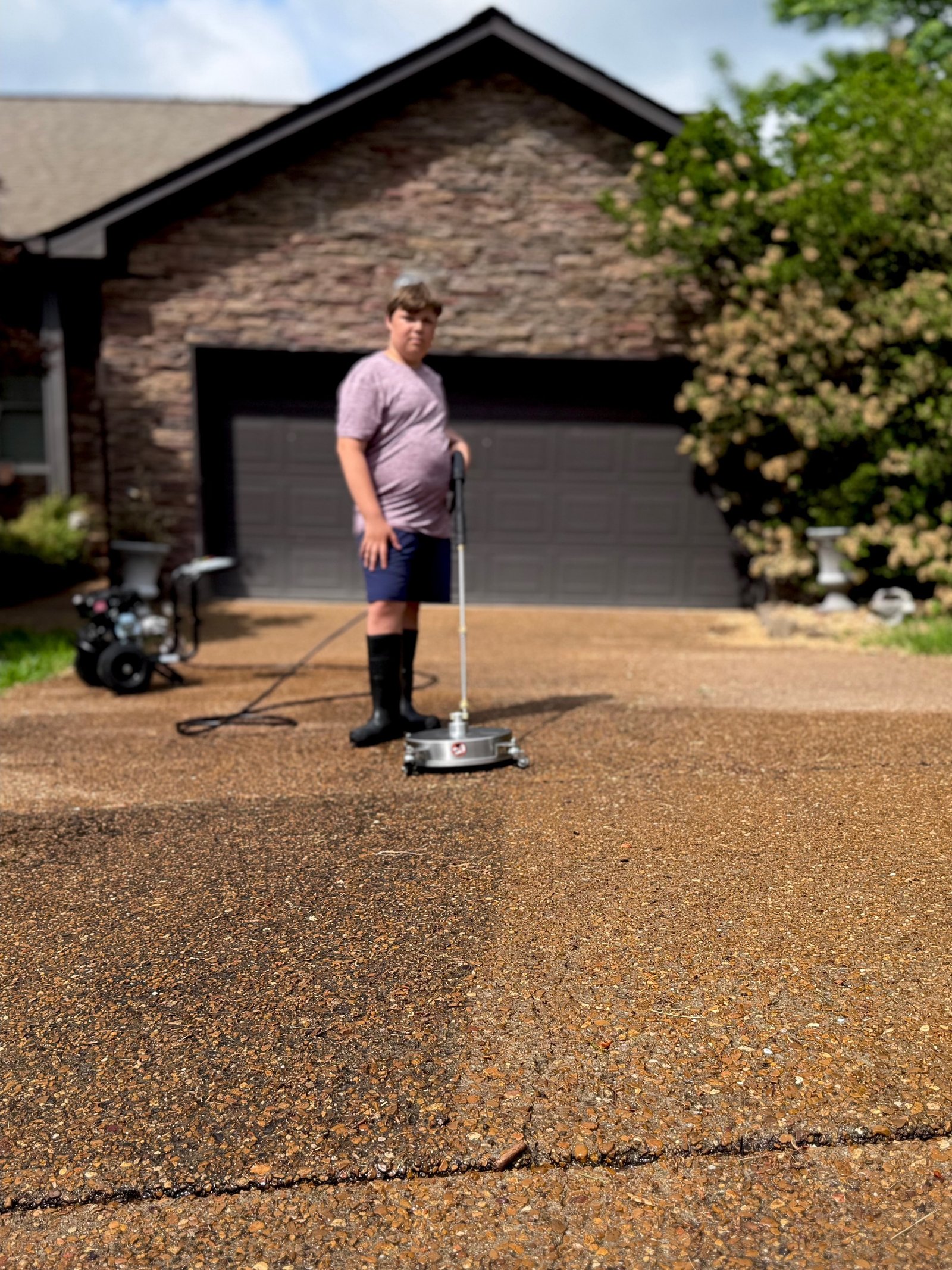 Side-by-side of a residential driveway. The left half shows years of dirt and tire grime; the right is bright, clean concrete.